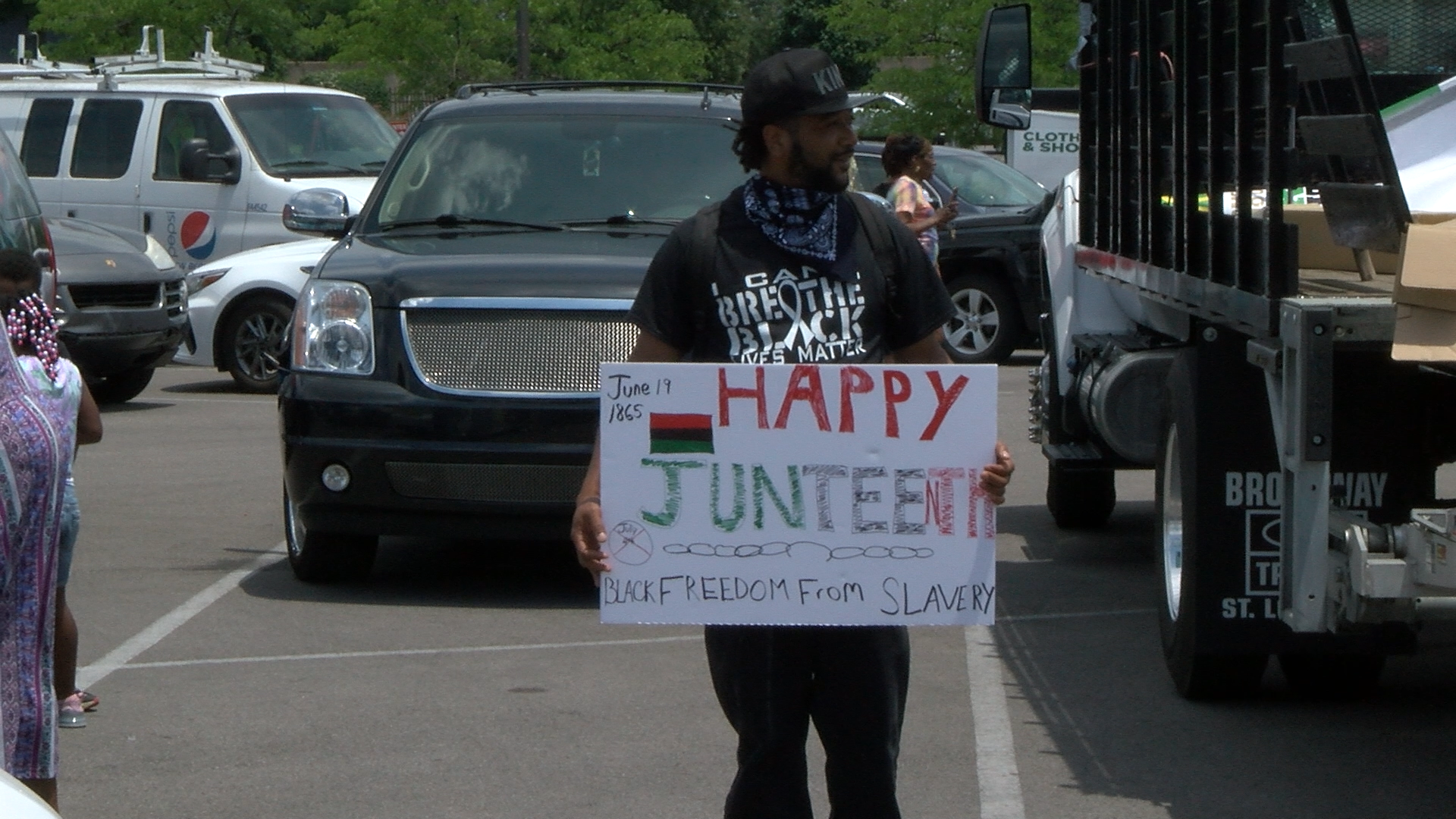 Man holds sign during Juneteenth celebration in St. Louis, 2020. (Photo: James Klein)